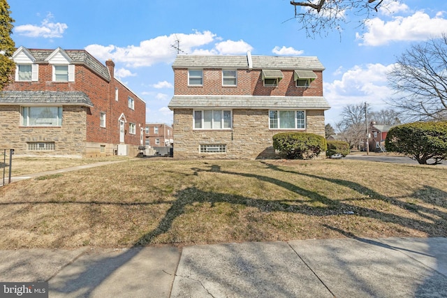 view of front of home featuring stone siding and a front yard