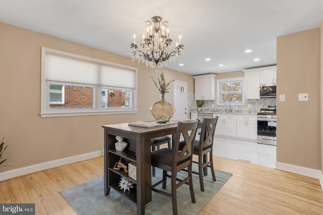 dining room featuring recessed lighting, baseboards, light wood-style floors, and an inviting chandelier