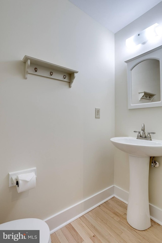 bathroom with sink, toilet, and hardwood / wood-style floors