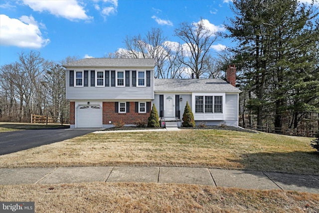 tri-level home featuring a front yard and a garage