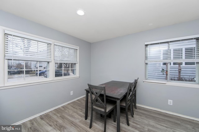 dining room with baseboards, wood finished floors, and recessed lighting