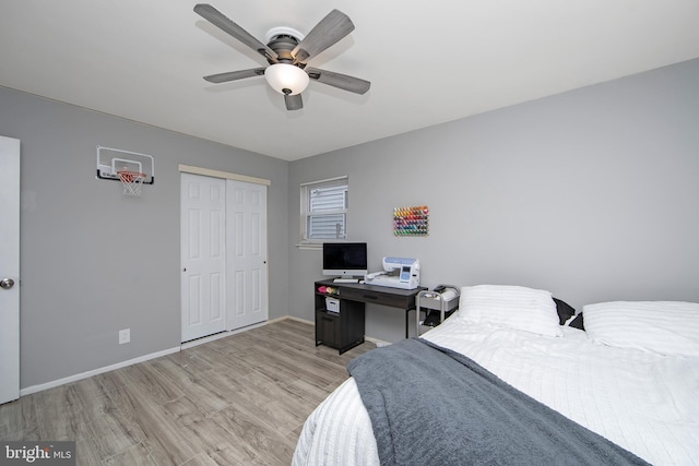 bedroom featuring light wood-type flooring, ceiling fan, baseboards, and a closet