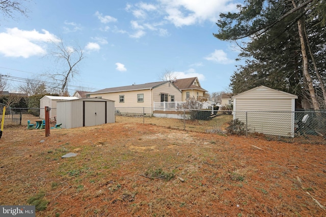 back of house featuring an outbuilding, a storage unit, and a fenced backyard