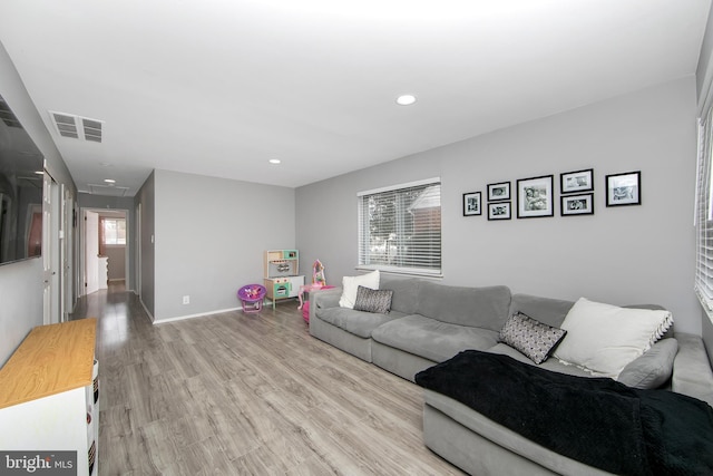 living room featuring attic access, baseboards, visible vents, light wood-style flooring, and recessed lighting