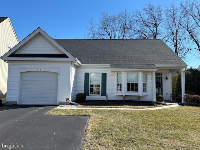 view of front of house with a shingled roof, a front lawn, aphalt driveway, and a garage