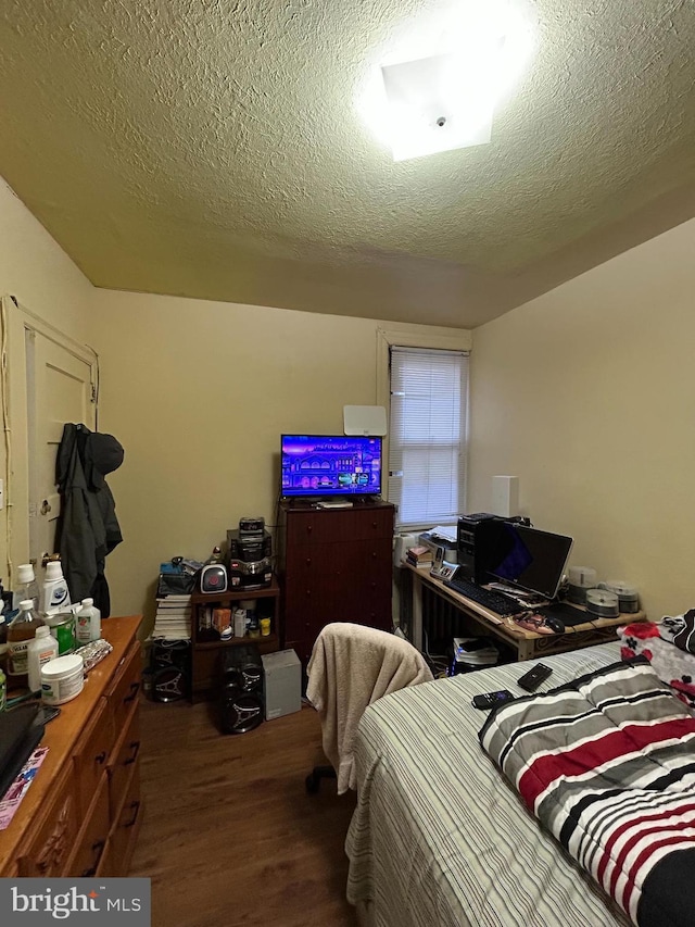 bedroom featuring a textured ceiling and wood finished floors