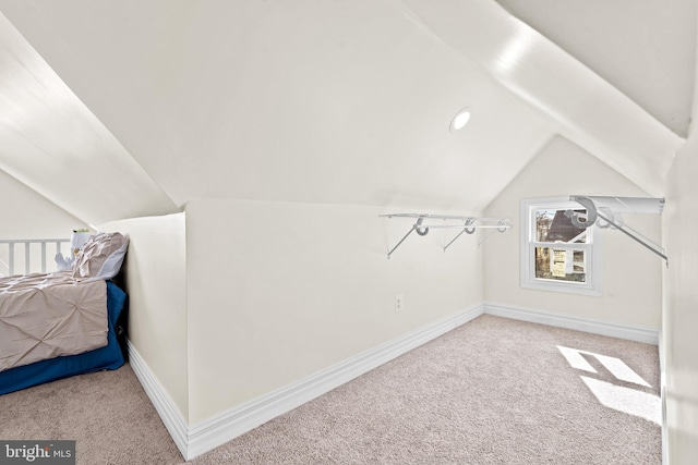 additional living space featuring lofted ceiling and light carpet