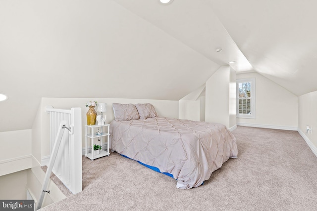 bedroom with lofted ceiling and light colored carpet