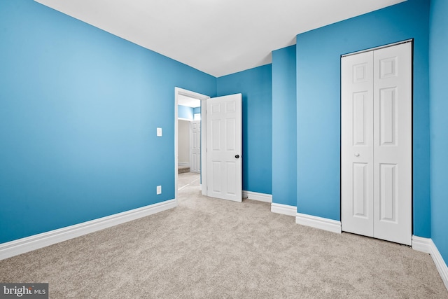 unfurnished bedroom with a closet and light carpet