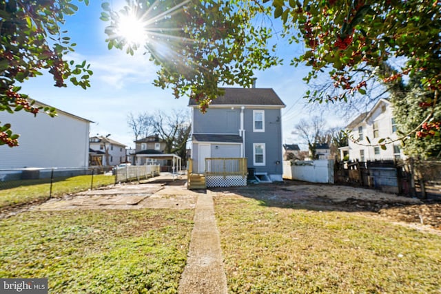 back of property with a lawn and a patio