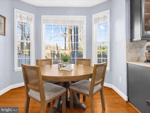 dining space with light wood-style flooring and baseboards