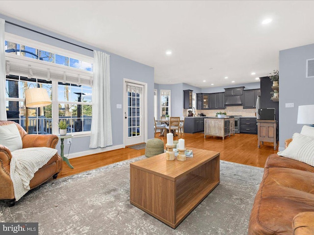 living area featuring a wealth of natural light, visible vents, light wood-style flooring, and recessed lighting