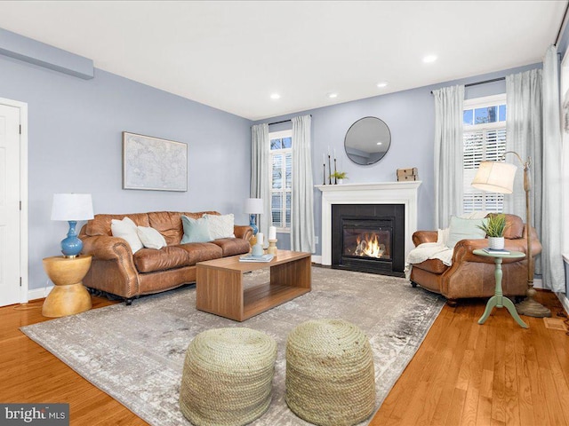 living area with recessed lighting, baseboards, wood finished floors, and a fireplace