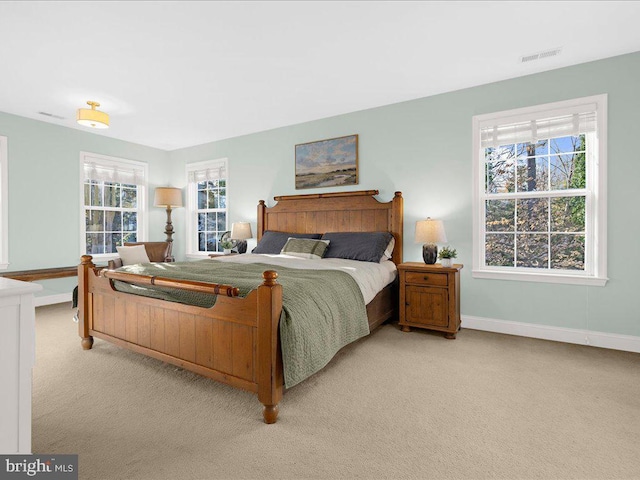 bedroom featuring visible vents, light carpet, and baseboards