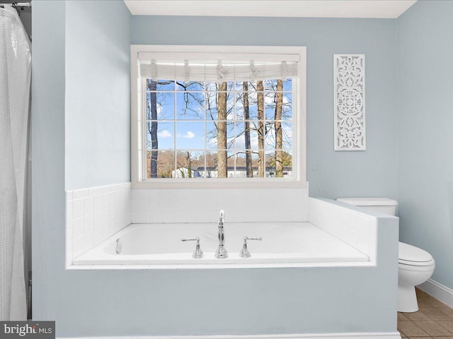 bathroom featuring a garden tub, toilet, and tile patterned floors