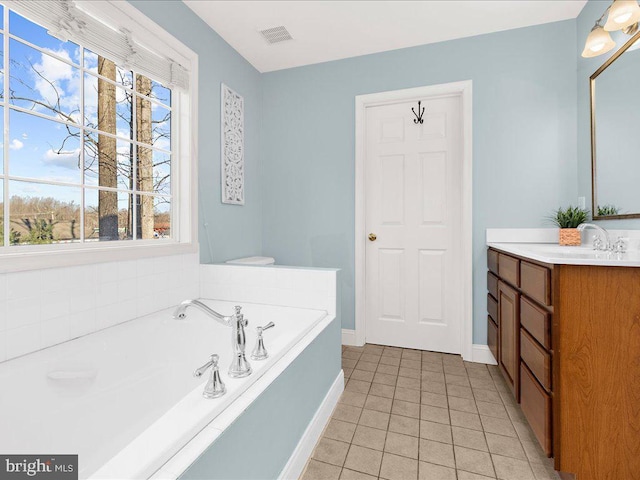 full bath featuring vanity, baseboards, visible vents, tile patterned floors, and a bath