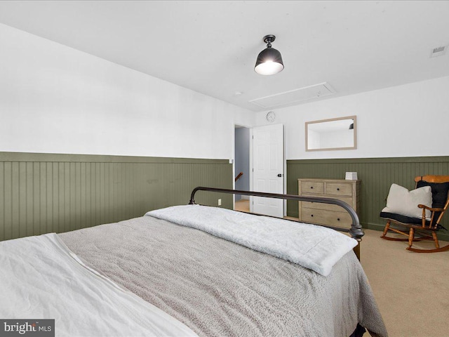 bedroom featuring attic access, carpet, visible vents, and wainscoting