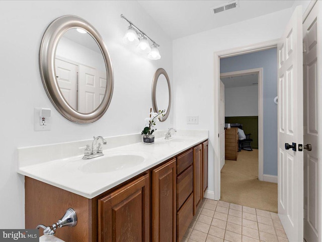 bathroom with a sink, visible vents, double vanity, and tile patterned floors