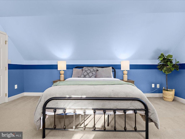 carpeted bedroom featuring baseboards and lofted ceiling