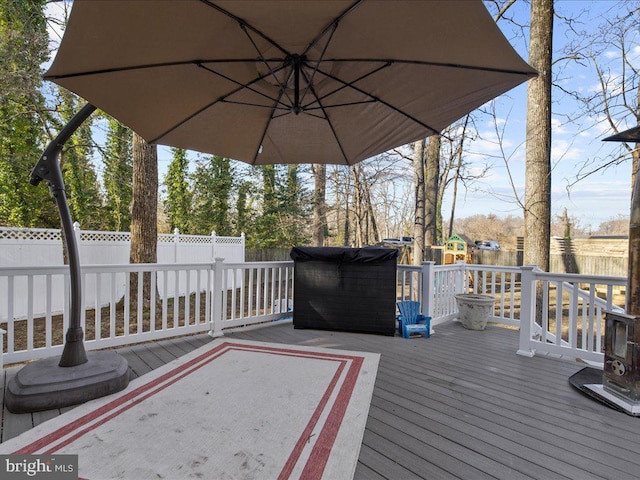 wooden deck with a fenced backyard