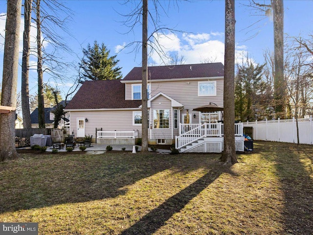 back of property featuring a lawn, a patio, a wooden deck, and a fenced backyard