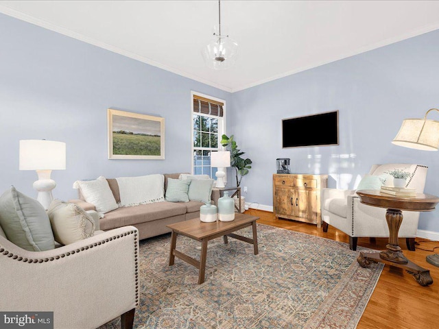 living room with wood finished floors, baseboards, and ornamental molding