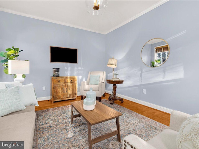 living area featuring crown molding, wood finished floors, and baseboards