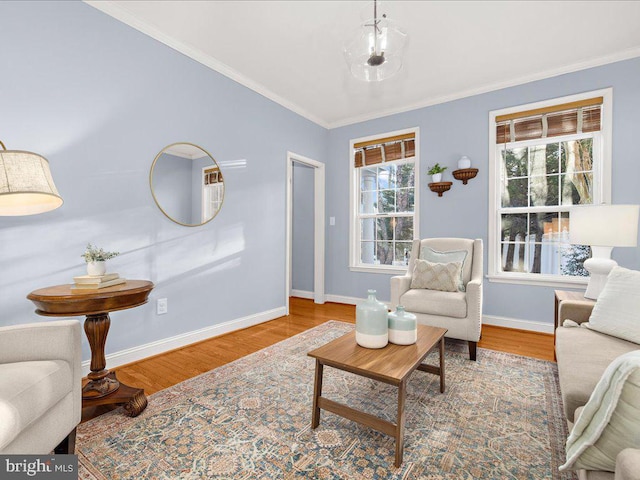 living room with wood finished floors, plenty of natural light, and ornamental molding