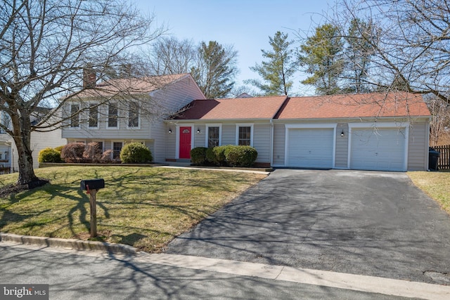 split level home with a garage, aphalt driveway, and a front yard