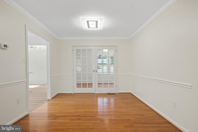 spare room with ornamental molding, french doors, baseboards, and light wood finished floors