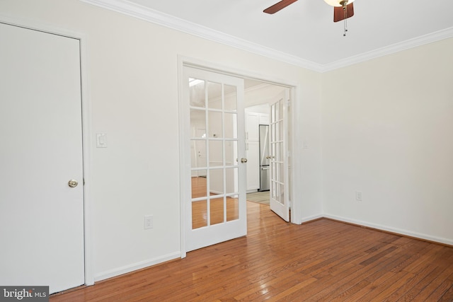 unfurnished bedroom featuring french doors, ornamental molding, ceiling fan, baseboards, and hardwood / wood-style flooring