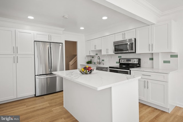 kitchen featuring stainless steel appliances, white cabinets, crown molding, and light wood-style flooring