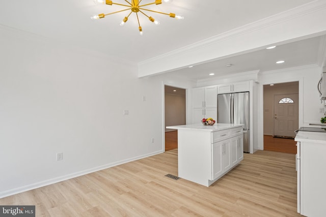 kitchen featuring stainless steel appliances, light wood-type flooring, white cabinetry, and ornamental molding