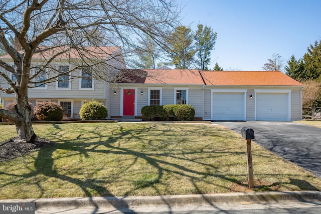 tri-level home with a garage, driveway, and a front lawn