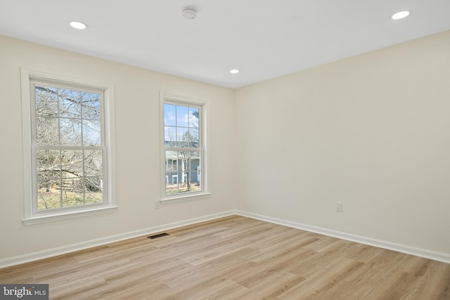 empty room with recessed lighting, visible vents, light wood-style flooring, and baseboards