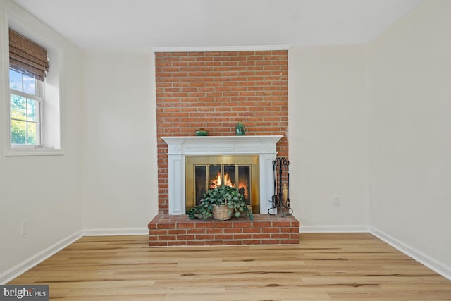 room details featuring a brick fireplace, wood finished floors, and baseboards