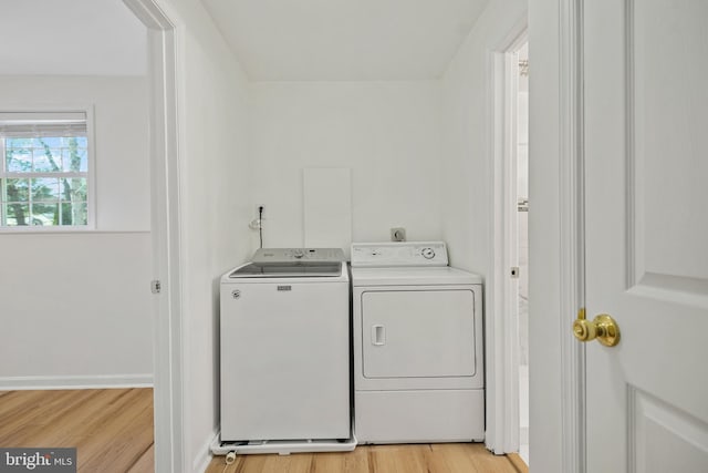 washroom with washer and clothes dryer, light wood-style flooring, and baseboards