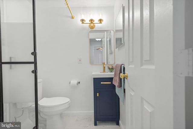 bathroom featuring marble finish floor, baseboards, vanity, and toilet