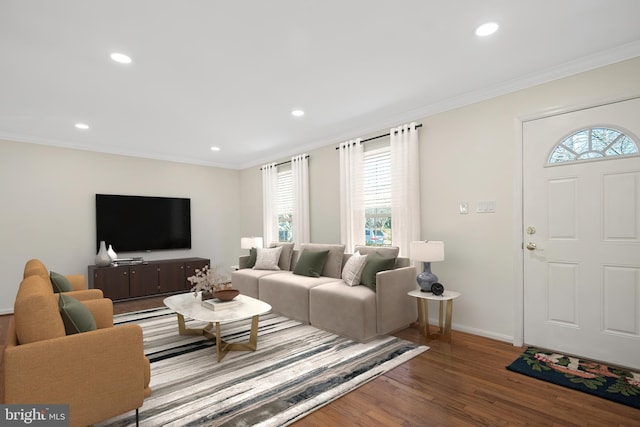 living room featuring ornamental molding, recessed lighting, baseboards, and wood finished floors