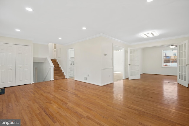 interior space with ornamental molding, french doors, light wood finished floors, and stairs