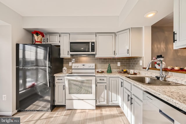 kitchen featuring stainless steel appliances, light stone countertops, sink, and backsplash