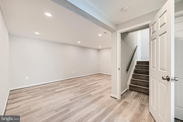 basement featuring ornamental molding and light hardwood / wood-style floors