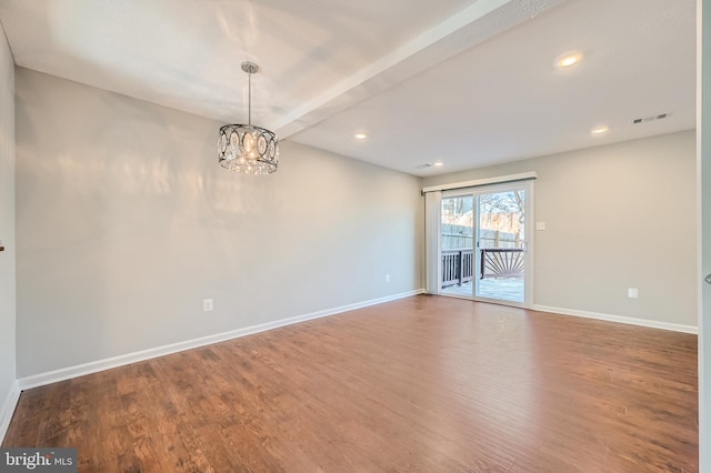 empty room featuring hardwood / wood-style flooring, a chandelier, and beamed ceiling