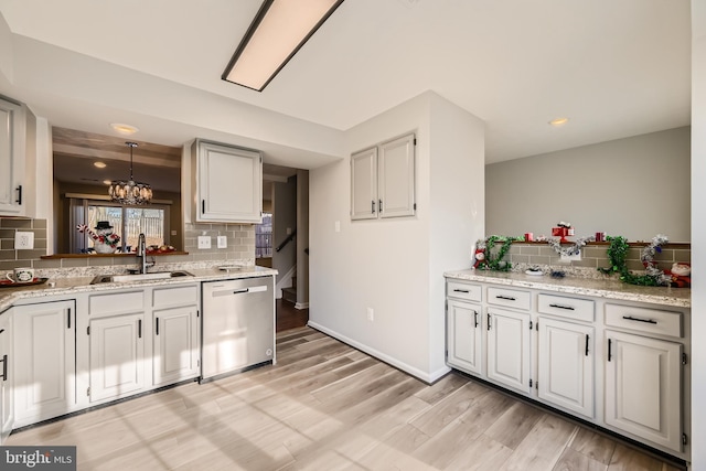 kitchen with sink, decorative light fixtures, stainless steel dishwasher, and white cabinets