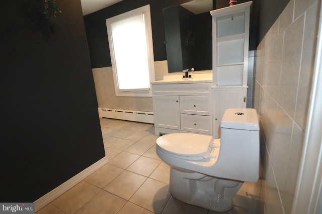 bathroom with tile walls, tile patterned flooring, vanity, baseboard heating, and toilet