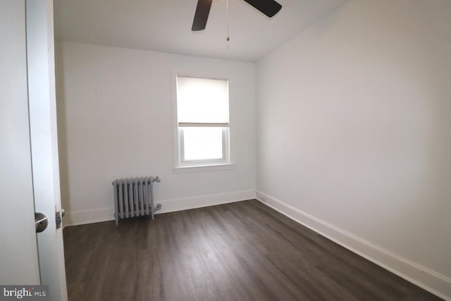 unfurnished room with ceiling fan, dark hardwood / wood-style floors, and radiator