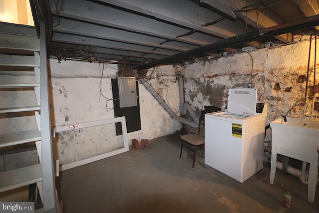 basement featuring electric panel and washer / dryer