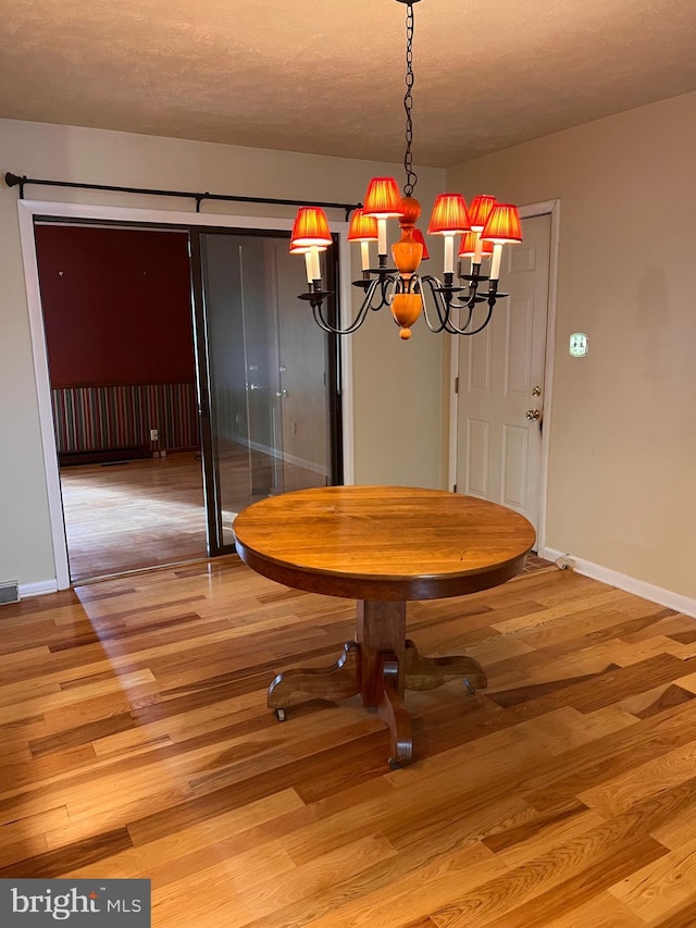 unfurnished dining area featuring light hardwood / wood-style floors and a chandelier