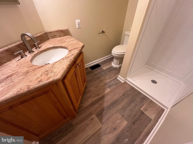 bathroom featuring vanity, toilet, hardwood / wood-style floors, and a shower