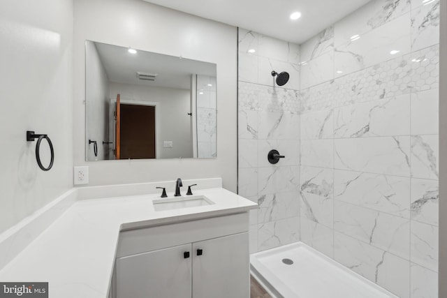 bathroom with vanity and tiled shower